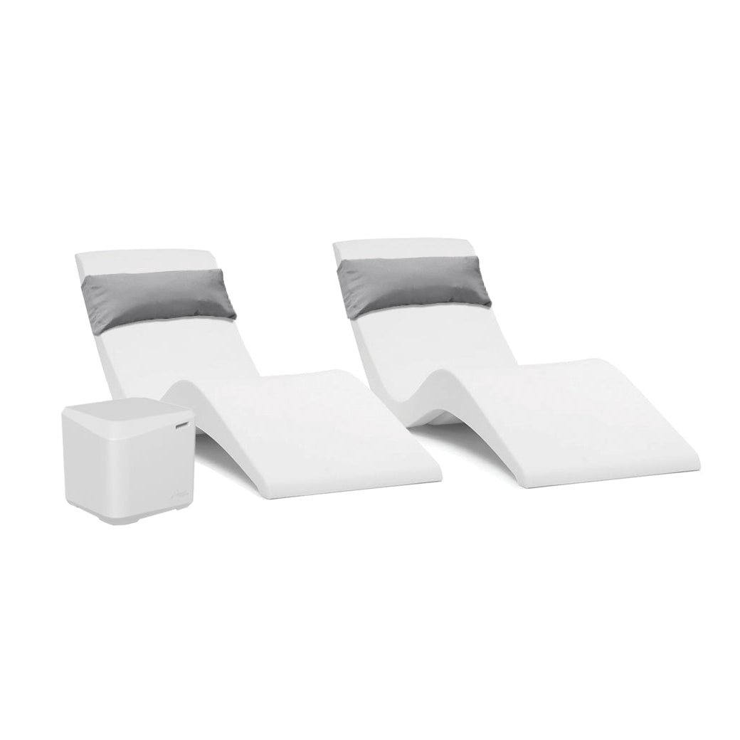 The AquaOutdoors Pool Lounge Chair Set features two white, modern chaise loungers with gray cushions in a sleek, wavy design. Paired with a small white cube table on a plain background, they provide style and comfort for your tanning shelf or sunlit patio.