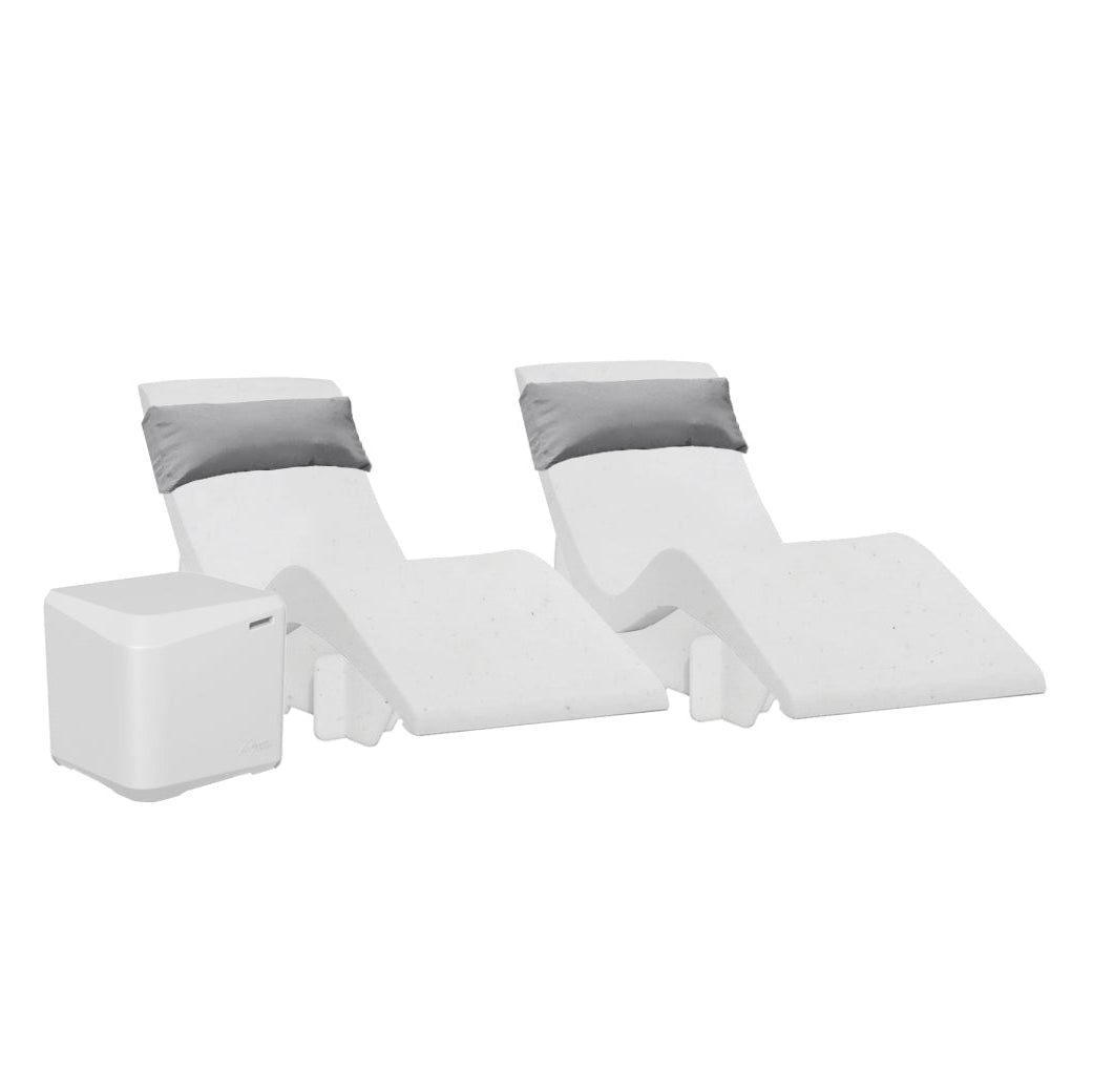 The AquaOutdoors Chaise Deep Ledge Bundle features two modern white recliners with sleek curves and grey headrest cushions, positioned beside a minimalist white table, ideal for your tanning shelf needs against a plain white backdrop.