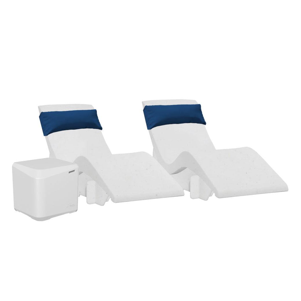 The AquaOutdoors Chaise Deep Ledge Bundle features two modern white chaise loungers with blue headrests in a sleek, wavy design, perfect for a tanning shelf. Accompanied by a small white side table, all items rest against a plain white background for a minimalistic vibe.