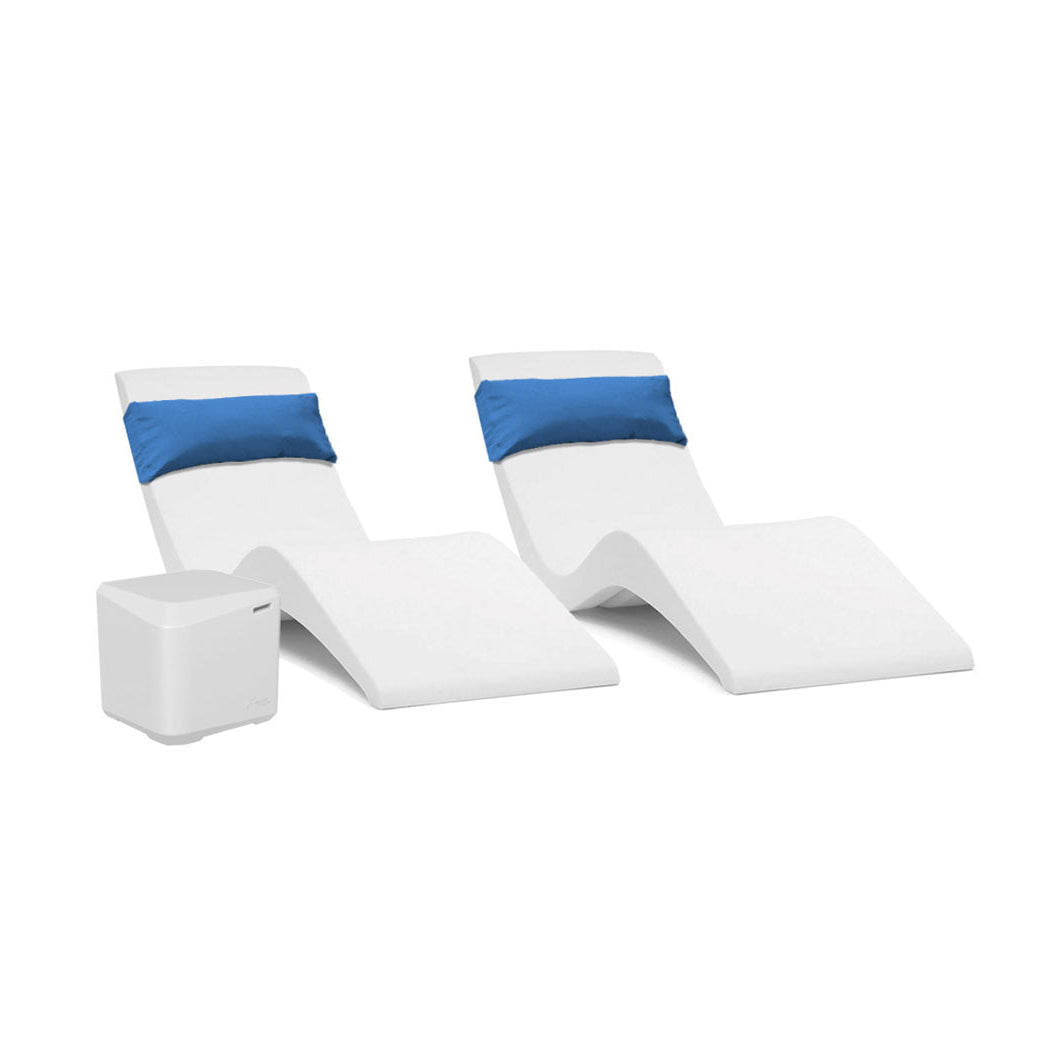 Two white pool lounge chairs with blue headrest pillows and a white side table.