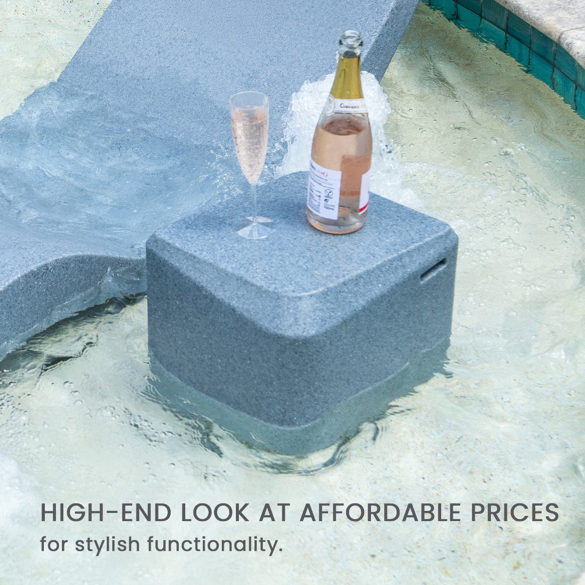 A champagne bottle and glass on a floating, gray cooler in a pool with a lounge chair nearby. Text reads, High-end look at affordable prices for stylish functionality.